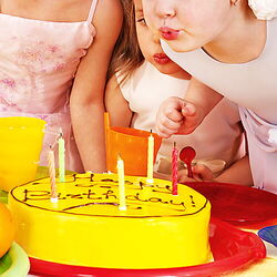 Kinder blasen die Kerzen auf einer Geburtstagstorte aus