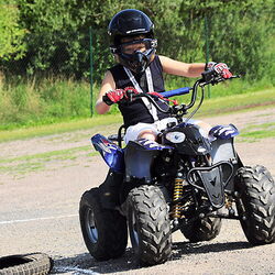 Ein junger Mann fährt mit einem Quad über einen Parcours